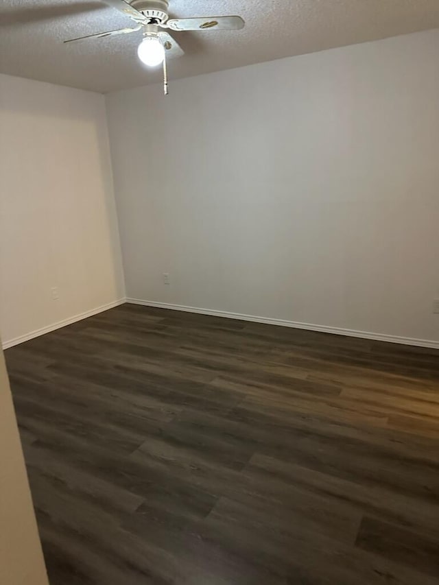 12660 Ashford Point Dr Unit 403, Houston, TX 77082 - empty room with dark wood-style floors, baseboards, a ceiling fan, and a textured ceiling