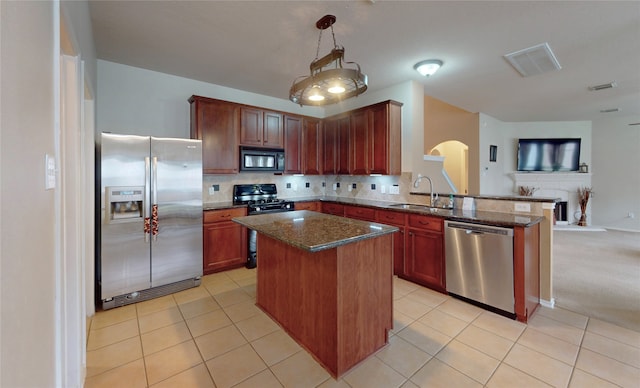 kitchen with a sink, black appliances, backsplash, arched walkways, and open floor plan