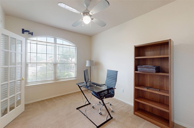home office featuring baseboards, ceiling fan, and light colored carpet