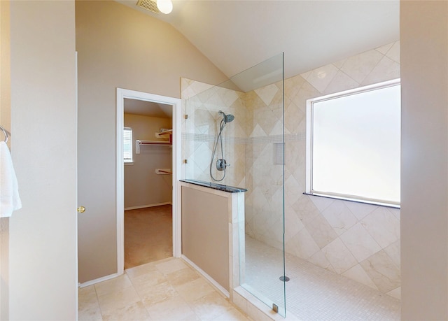 full bathroom with walk in shower, a spacious closet, visible vents, and vaulted ceiling