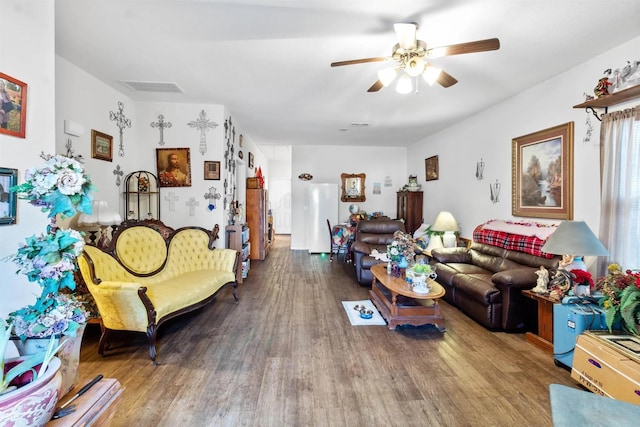 living area featuring visible vents, wood finished floors, and a ceiling fan