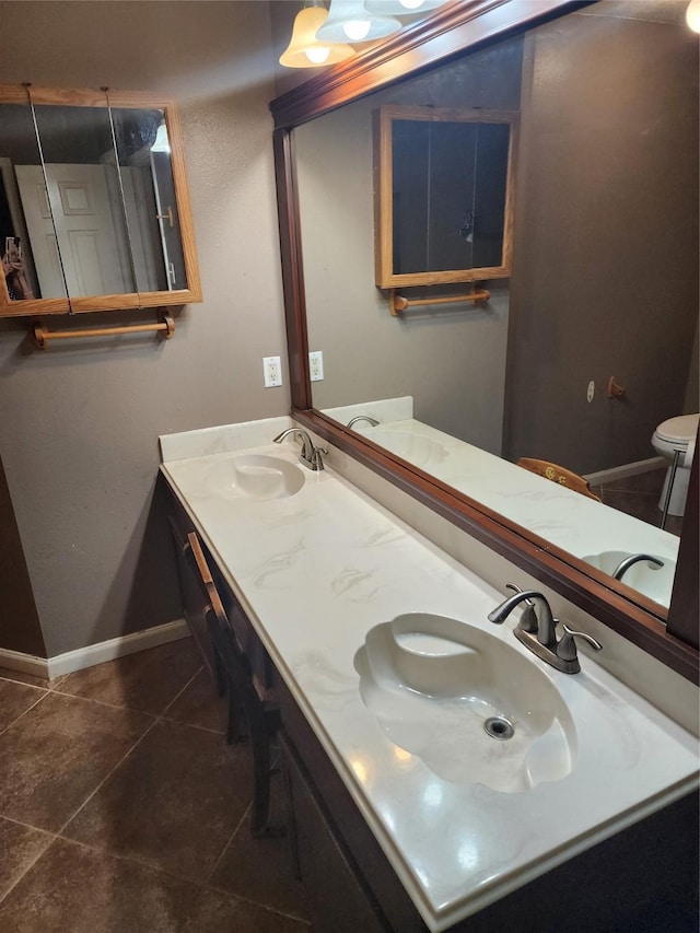 9316 Tejas Ct, La Porte, TX 77571 - bathroom with tile patterned floors, baseboards, double vanity, and toilet