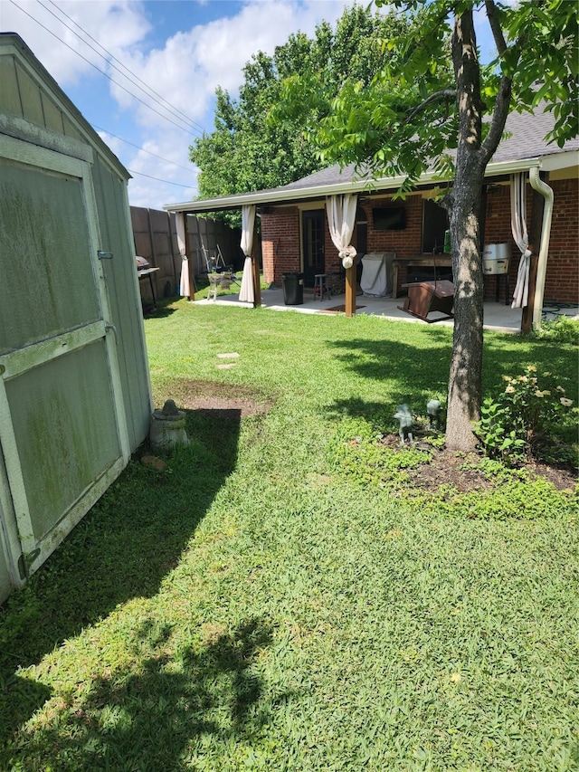 9316 Tejas Ct, La Porte, TX 77571 - view of grassy yard featuring a patio, a shed, and an outbuilding