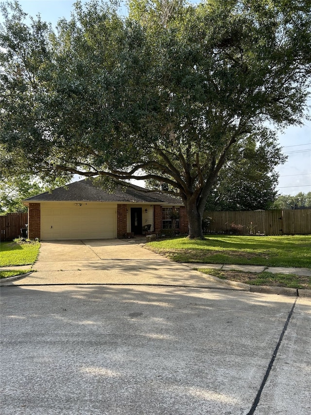 9316 Tejas Ct, La Porte, TX 77571 - view of front facade featuring fence, an attached garage, driveway, and brick siding