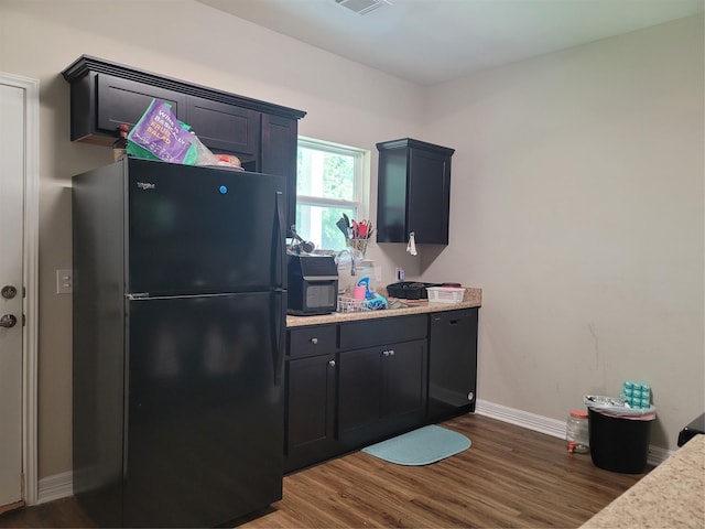 kitchen featuring dark wood-style flooring, visible vents, freestanding refrigerator, and baseboards