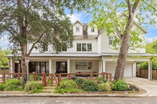 412 Redan St, Houston, TX 77009 - view of front of house featuring a standing seam roof, an attached garage, driveway, covered porch, and metal roof