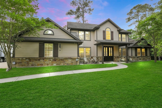 16711 Wagon Wheel Rd, Stagecoach, TX 77355 - back of property at dusk featuring a lawn, french doors, a shingled roof, and stone siding