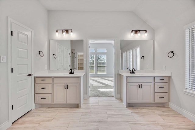 9306 Eckert Rd, Iowa Colony, TX 77583 - full bath featuring two vanities, a sink, vaulted ceiling, and baseboards