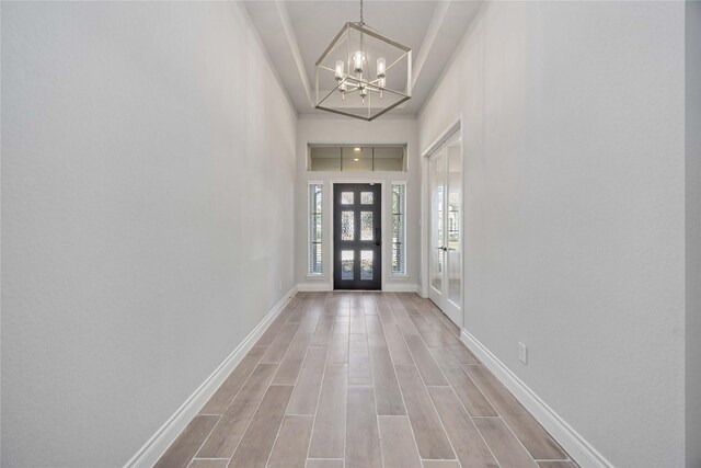 9306 Eckert Rd, Iowa Colony, TX 77583 - entryway featuring baseboards, wood finished floors, and an inviting chandelier