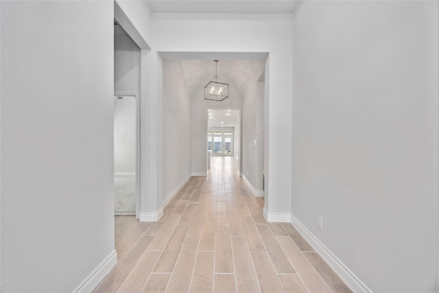 9306 Eckert Rd, Iowa Colony, TX 77583 - hallway featuring baseboards, a chandelier, and light wood-style floors
