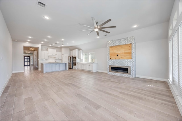 9306 Eckert Rd, Iowa Colony, TX 77583 - unfurnished living room with a wealth of natural light, visible vents, ceiling fan, and a tile fireplace