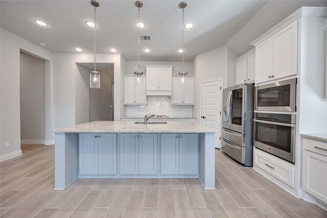 9306 Eckert Rd, Iowa Colony, TX 77583 - kitchen with light wood finished floors, a sink, white cabinets, and appliances with stainless steel finishes
