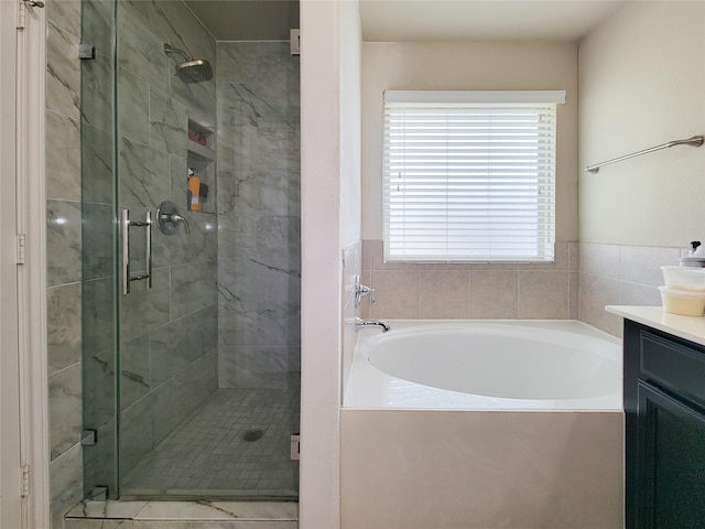 full bathroom with a bath, a shower stall, and vanity