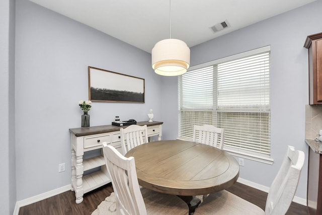 dining space featuring dark wood-type flooring, visible vents, and baseboards