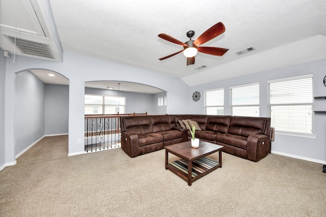 living area featuring a ceiling fan, visible vents, carpet, and a healthy amount of sunlight