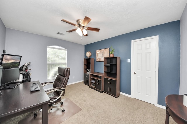 carpeted home office with visible vents, a ceiling fan, and baseboards