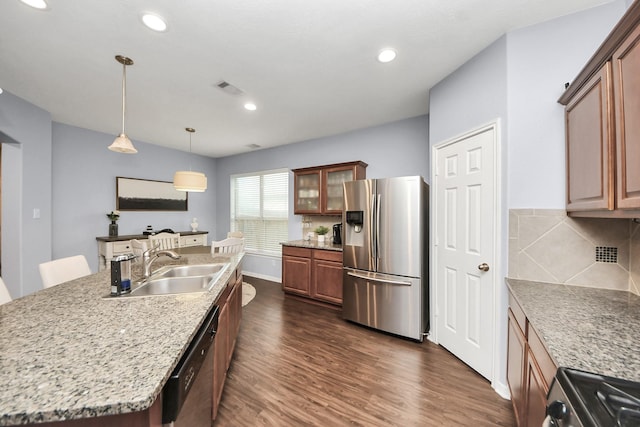 kitchen with decorative backsplash, a sink, appliances with stainless steel finishes, visible vents, and dark wood-type flooring