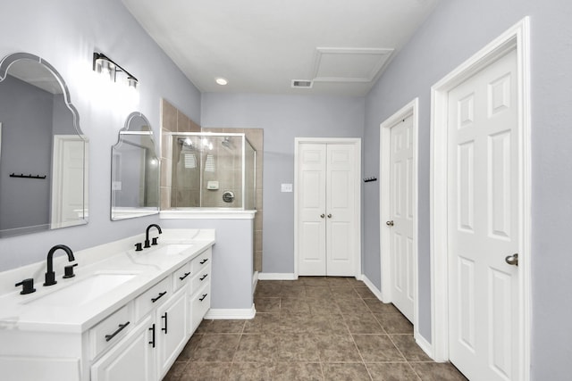 bathroom featuring visible vents, a stall shower, double vanity, and a sink