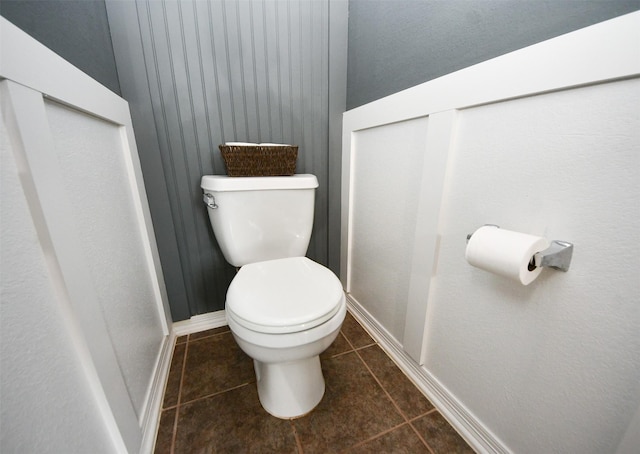 bathroom featuring toilet, tile patterned floors, and baseboards