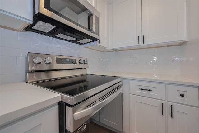 kitchen featuring white cabinetry, appliances with stainless steel finishes, light stone counters, and tasteful backsplash