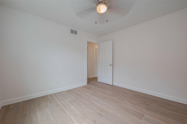 unfurnished room featuring baseboards, ceiling fan, light wood finished floors, and visible vents