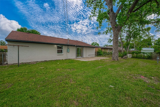 back of property with a fenced backyard, a patio, and a yard