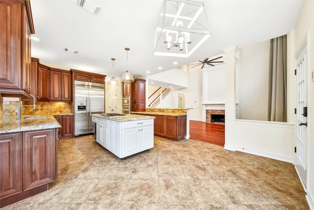 kitchen with visible vents, appliances with stainless steel finishes, a fireplace, and decorative backsplash