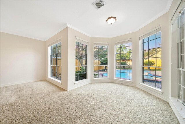 unfurnished sunroom with visible vents, crown molding, and carpet floors