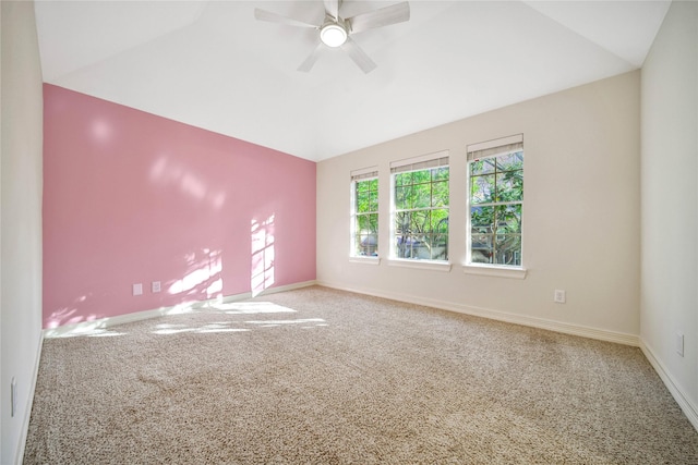 carpeted spare room with baseboards, ceiling fan, and vaulted ceiling