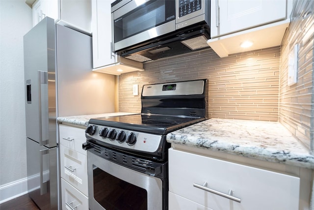 kitchen featuring baseboards, light stone countertops, decorative backsplash, appliances with stainless steel finishes, and white cabinetry