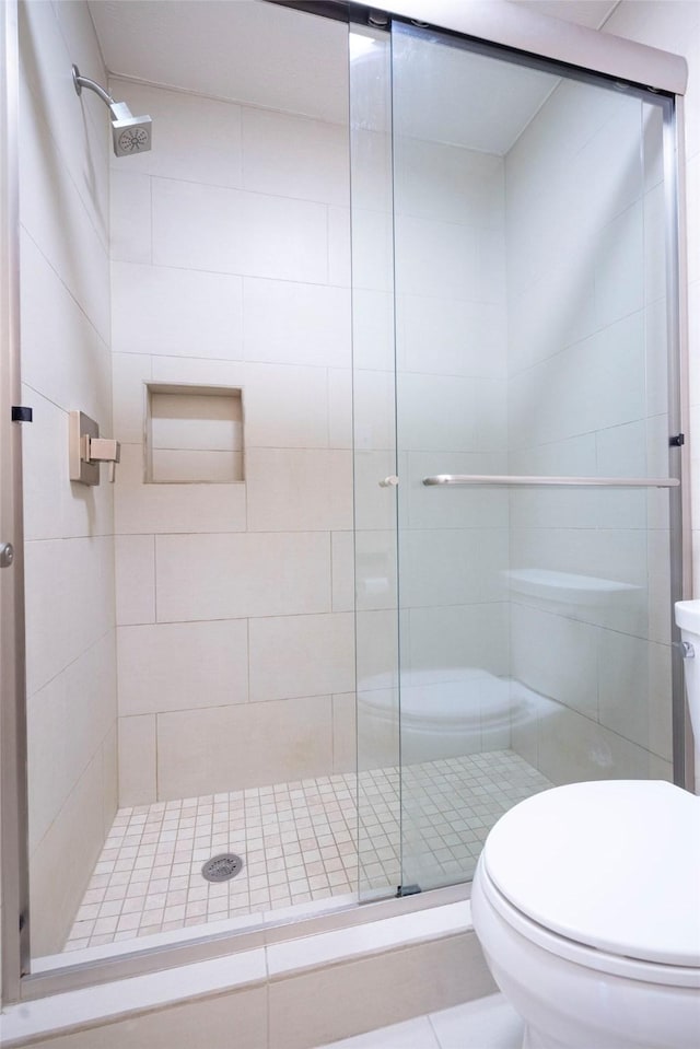 full bathroom with a shower stall and toilet