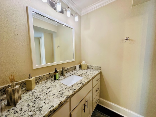 bathroom featuring baseboards, ornamental molding, and vanity
