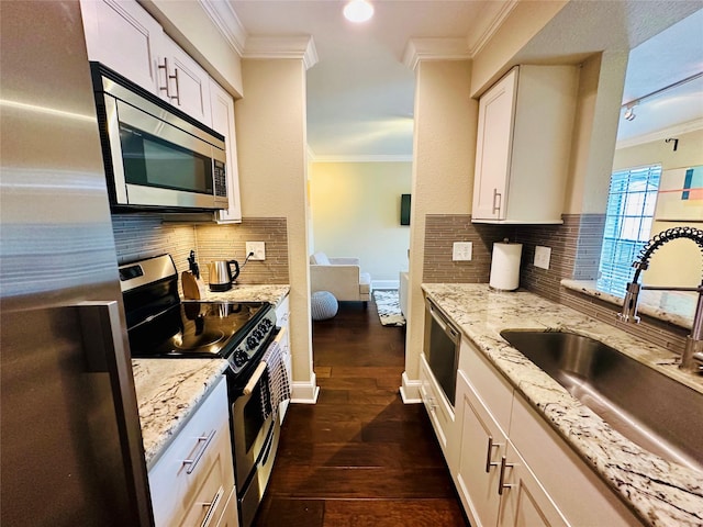 kitchen with crown molding, dark wood-style floors, a sink, and appliances with stainless steel finishes