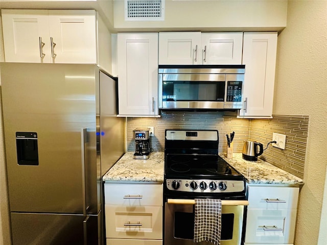 kitchen with tasteful backsplash, visible vents, stainless steel appliances, and white cabinets