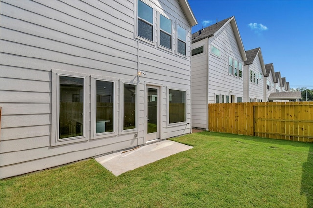 back of property with fence and a lawn