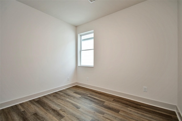 unfurnished room featuring baseboards and dark wood-style flooring