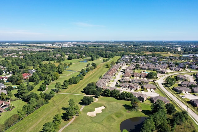 aerial overview of property's location with a nearby body of water, nearby suburban area, a golf club, and a tree filled landscape