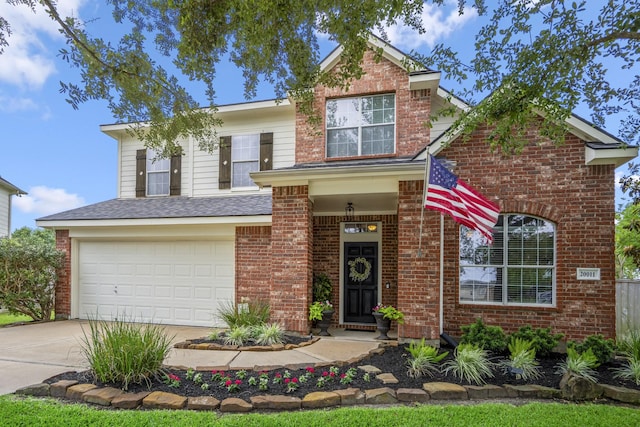 traditional home with driveway, brick siding, a garage, and a shingled roof