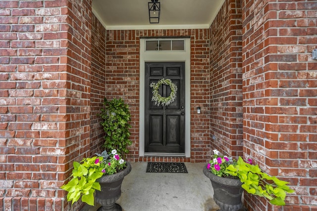 entrance to property featuring brick siding and a porch