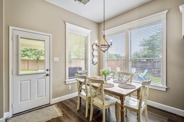 dining room with a chandelier, dark wood-style flooring, and baseboards