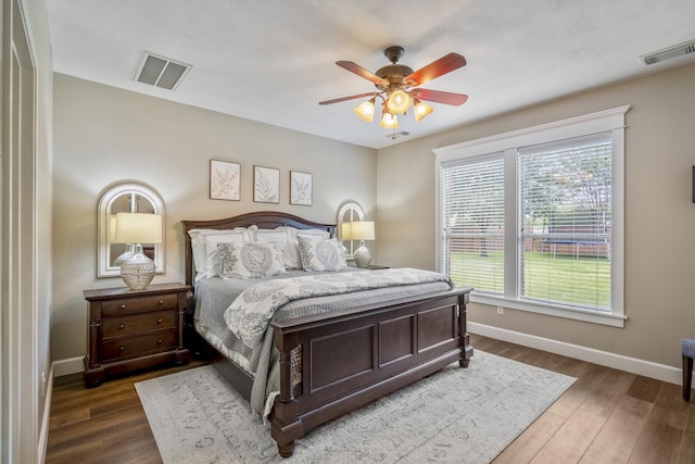 bedroom featuring baseboards, wood finished floors, and ceiling fan