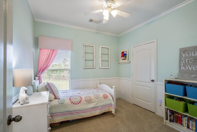 bedroom featuring carpet floors, ornamental molding, wainscoting, and a ceiling fan