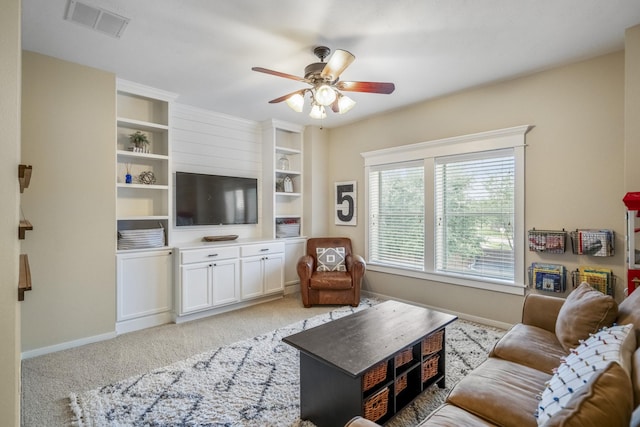 living room with a ceiling fan, baseboards, and light carpet