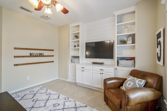 living area with ceiling fan, light colored carpet, and baseboards