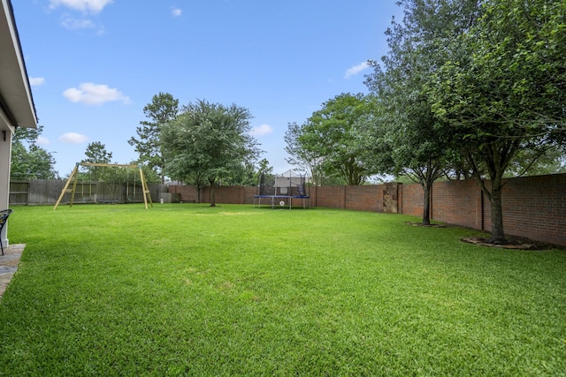 view of yard featuring a trampoline and a playground