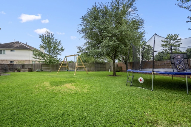view of yard featuring a trampoline and a playground
