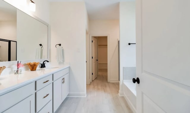 1575 Little Cypress Loop, Orange, TX 77632 - full bathroom with wood finished floors, a stall shower, a spacious closet, double vanity, and a bath