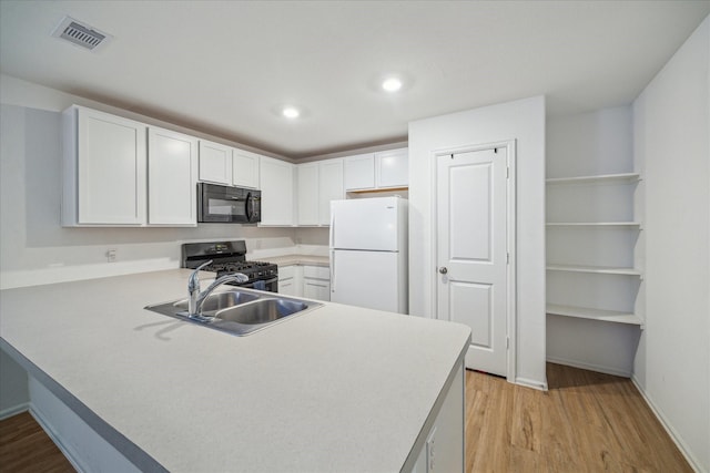 8834 Wooster Trails Dr, Baytown, TX 77521 - kitchen featuring visible vents, light wood-type flooring, white cabinets, a sink, and black appliances