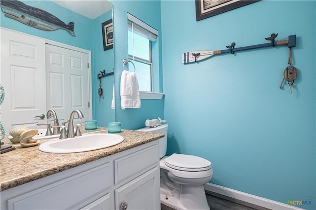 106 Clement Cv, Port Lavaca, TX 77979 - bathroom featuring toilet, vanity, wood finished floors, and baseboards