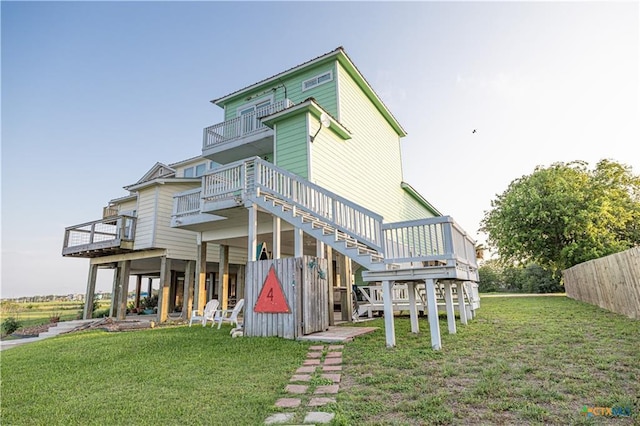 106 Clement Cv, Port Lavaca, TX 77979 - back of property with stairway, a wooden deck, a balcony, and a lawn